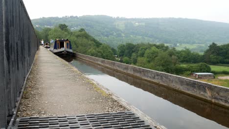 British-tourist-steering-canal-boats-on-iconic-Pontcysyllte-Aqueduct-Welsh-countryside-waterway