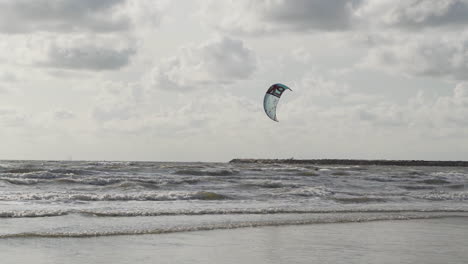 Kite-surfer-surfing-over-sea-and-jumping-up-in-slow-motion