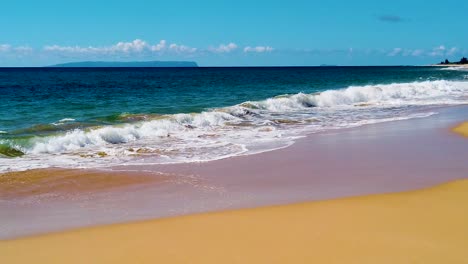 HD-Hawaii-Kauai-slow-motion-pan-right-to-left-from-the-beach-along-lower-and-right-frame-past-an-island-in-the-distance-to-ocean-waves-crashing-edge-to-edge-in-center-of-frame-with-mostly-sunny-sky