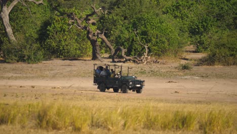 Open-4x4-truck-drives-tourists-on-wildlife-safari-through-Chobe-National-Park-in-Botswana