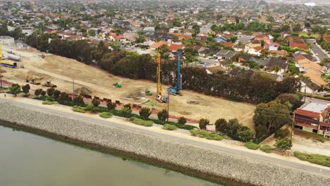 Rotating-aerial-view-of-coastline-construction-and-heavy-machinery
