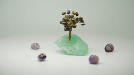 Teure-Kristalldrahtbäume-Mit-Grünem-Amethyst,-Umgeben-Von-Fünf-Violetten-Kristallen-Auf-Einem-Drehteller-–-Nahaufnahme