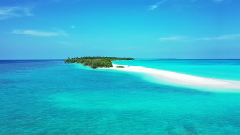 Pristine-exotic-beach-with-long-sandy-stripe-extended-to-wide-turquoise-lagoon-around-tropical-island-on-a-bright-light-blue-sky-in-Bora-bora