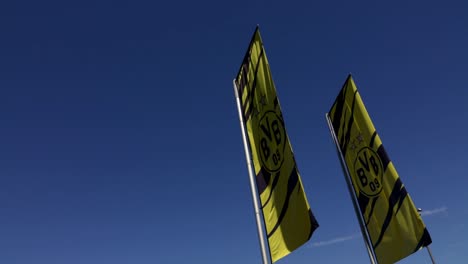 Borrusia-Dortmund-BVB-Flag-slow-motion-against-blue-sky,-medium-shot