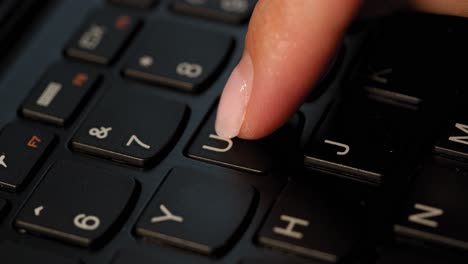 Pushing-U-button-on-the-black-keyboard