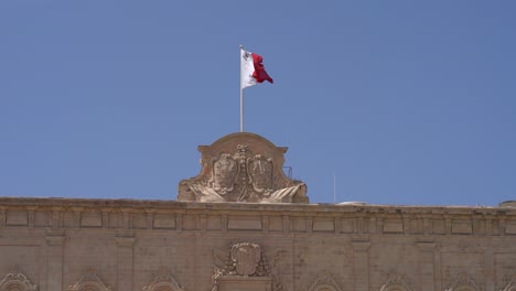 Toma-En-Cámara-Lenta-De-La-Bandera-Maltesa-Ondeando-En-El-Viento,-Malta
