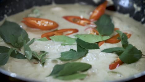 Garnishing-Boiling-Green-Curry-with-Red-Chili-and-Green-Thai-Basil---Close-Up