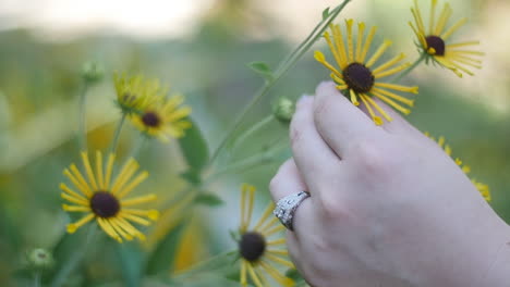 Hand-with-engagement-ring-holding-a-quilled-brown-eyed-susan-flower