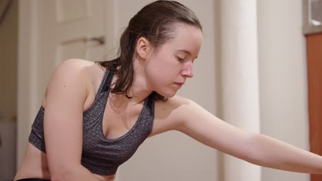 Young-woman-stretching-during-her-daily-workout-routine-at-home