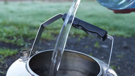 Filling-Stainless-Steel-Camping-Kettle-With-Spring-Water---Closeup-Shot