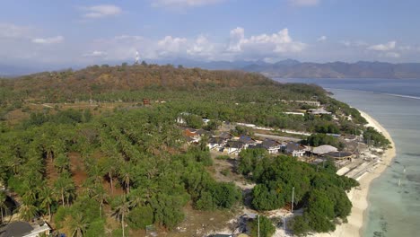 Aerial-wide-shot-of-green-hills-on-Gili-Trawangan-Island-with-beach-and-ocean-during-sunlight