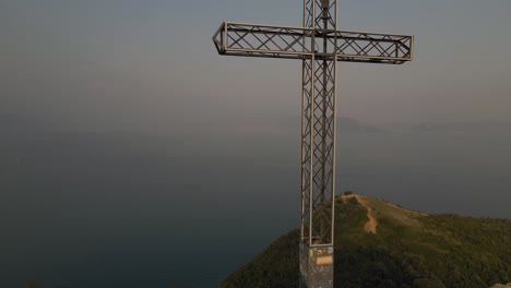 Cross-on-mountain-summit,-Lake-Garda,-Manerba,-aerial-view