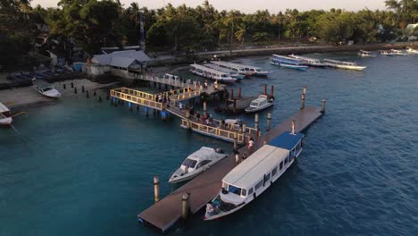 Aerial-flyover-Gili-Air-Dock-Pier-while-tourists-arriving-after-boats-tour-on-indian-ocean