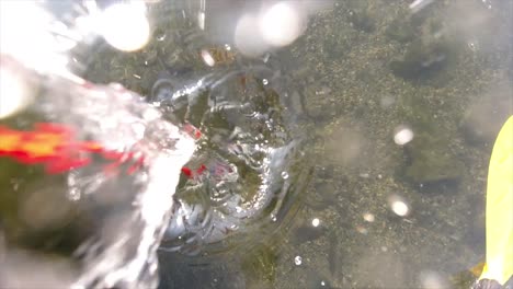 top-view-of-Dropping-a-magnet-for-magnet-fishing-in-slow-motion-into-a-river-and-watching-the-splash-and-bubbles-as-the-fisher-searches-for-treasures-on-the-river-bead