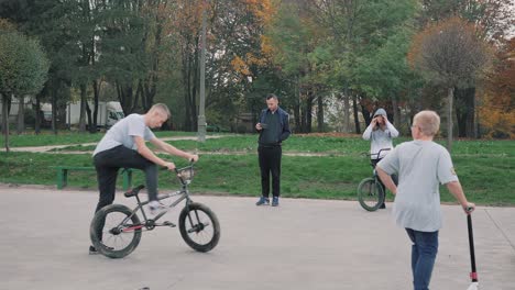 Skatepark-boy-recording-by-phone-a-young-man-riding-a-BMX