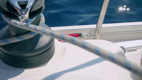 Rope-Being-Pulled-Through-A-Winch-Of-A-Boat-Sailing-Over-The-Sea---close-up