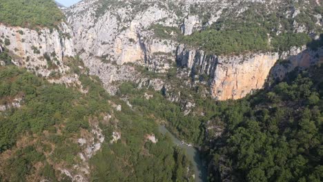 High-flying-drone-shot-over-a-river-running-through-a-large-canyon-in-France