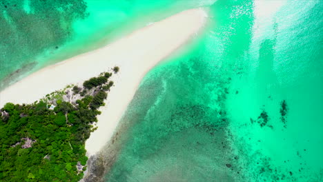 fly-over-of-a-white-beach-jutting-into-gorgeous-turquoise-green-water-in-Madagascar