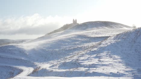 Wind-Treibt-Schnee-In-Hügeligem-Berggebiet-Und-Bildet-Einen-Schneesturm