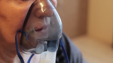 Extreme-close-up-shot-of-an-older-woman-using-a-respiratory-mask-inhaling-medicine-to-clear-out-her-throat-and-sinuses