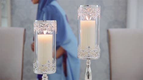 Muslimische-Frau-Stellt-Brennende-Kerzen-In-Eleganten-Glaskerzenhaltern-Auf-Den-Tisch-–-Mittlere-Aufnahme