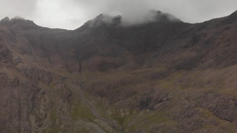 Backwards-drone-shot-of-mountain-landscape-in-isle-of-skye-scotland