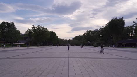 Wide-open-view-of-Ueno-Park-square-at-cloudy-dusk-with-people-walking
