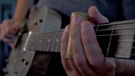 Man-Playing-Old-Metallic-Resonator-Guitar-with-Slide-Close-Up-Neck
