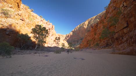 Person-walks-across-sand-through-gorge,-Central-Australia