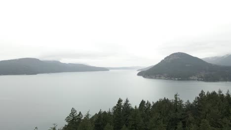 Looking-out-from-Obstruction-Point,-Orcas-Island-slowly-descending-into-the-forest-canopy,-aerial