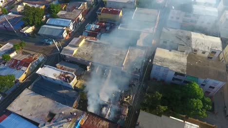 Aerial-drone-view-around-a-house-on-fire,-due-to-a-bomb-attack,-during-sunset