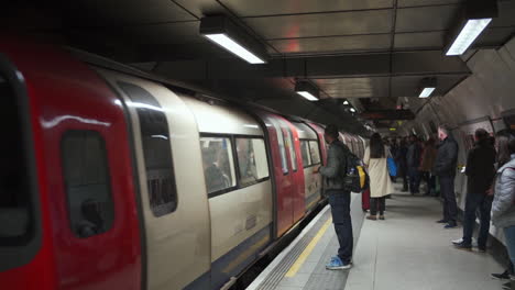 London-Underground,-Train-Arriving-at-Metro-Station,-People-Traveling-on-Christmas-Holidays,-Slow-Motion,-England-UK