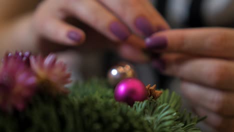 Woman-making-a-fir-Advent-wreath-for-Christmas-Eve-and-decorating-it,-diy-craft-decoration,-winter-traditions,-seasonal-holidays,-de-focused-hands-close-up-shot