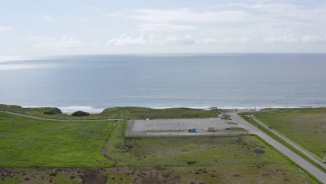 Aerial:-parking-lot-and-ocean-view-in-Half-Moob-Bay-beach,-panning-right