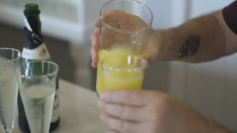 Bartender-adding-orange-juice-to-champagne-cocktail-at-wedding-party