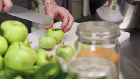 Female-Chef-Cutting-Fresh-Green-Apples-In-The-Kitchen---close-up,-slow-motion