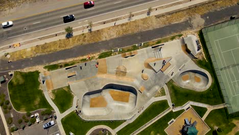 Descending-aerial-spinning-view-of-an-urban-skate-park-and-activity-center