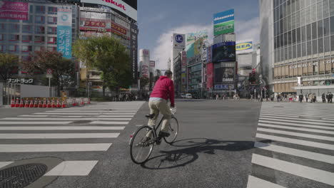 Mann-Auf-Dem-Fahrrad-überquert-Shibuya-Mit-Einer-Menschenmenge-Während-Des-Pandemieausbruchs-In-Tokio,-Japan