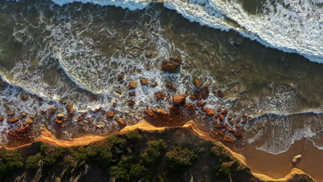 AERIAL-DIRECTLY-ABOVE-Limestone-Cliff,-Waves-Crashing,-Coastal-Erosion