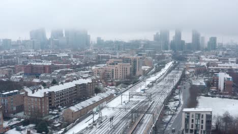 stable-aerial-drone-shot-of-Snow-covering-Central-London-and-train-tracks