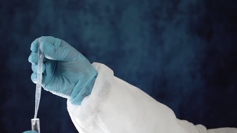 Gloved-hand-uses-pipette-to-drop-vaccine-in-test-vial