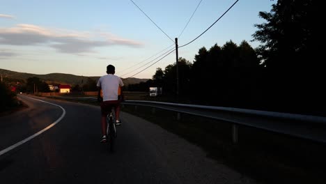 Niño-Monta-Su-Bicicleta-En-Un-Camino-Rural-Al-Atardecer-En-Un-Día-De-Verano