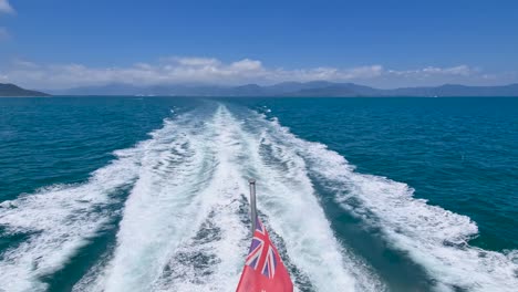 Die-Flagge-Der-Australischen-Red-Ensign-Weht-Gegen-Die-Wellen-Vom-Bootssegeln-Zum-Great-Barrier-Reef