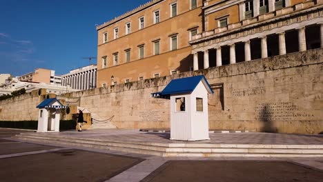 Two-Greek-presidential-guards-with-traditional-military-uniform,-evzone,-are-ending-the-ceremonial-guard-change-in-front-of-the-Hellenic-Parliament