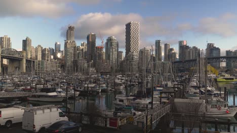 Fisherman's-Wharf-marina-where-small-boats-are-docked-anchored-at-a-waterfront-and-the-cityscape-with-high-rise-buildings-in-the-background-blue-sky-clouds-bridge