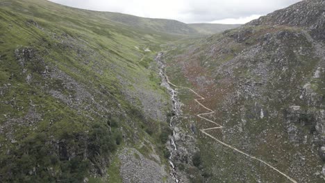 Aerial-View-Of-The-Hiking-Trail-In-The-Wicklow-Mountains-Near-The-Glendalough-Upper-Lake-In-County-Wicklow,-Ireland---panning-drone-shot
