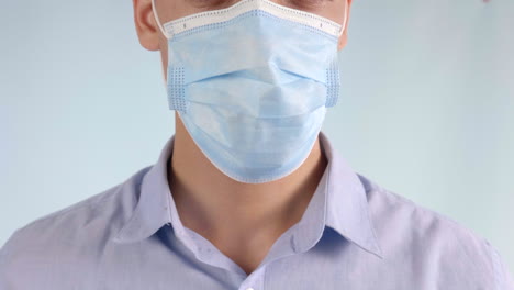 Extreme-Closeup-of-Man-Putting-Disposable-Face-Mask-Over-Mouth-and-Nose