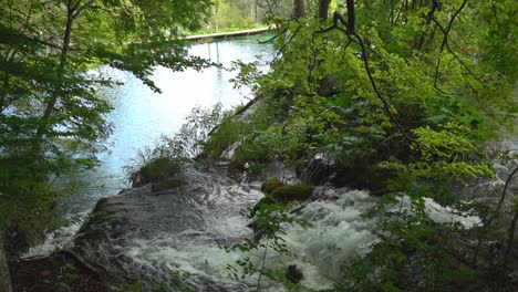 Kaskadierende-Wasserfälle-Fließen-Mit-¼-Geschwindigkeit-In-Ein-Türkisfarbenes-Becken-In-Der-Nähe-Einer-Promenade-Im-Nationalpark-Plitvicer-Seen-In-Kroatien,-Europa
