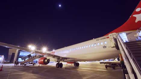 Corendon-airlines-plane-landed-at-the-local-airport-at-night,-waiting-for-passengers-to-board-in