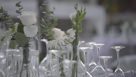 Weiße-Rosen-Auf-Dem-Vom-Wind-Verwehten-Tisch-Bei-Der-Hochzeitsfeier-Im-Freien-An-Einem-Windigen-Tag,-Nahaufnahme,-Zeitlupe